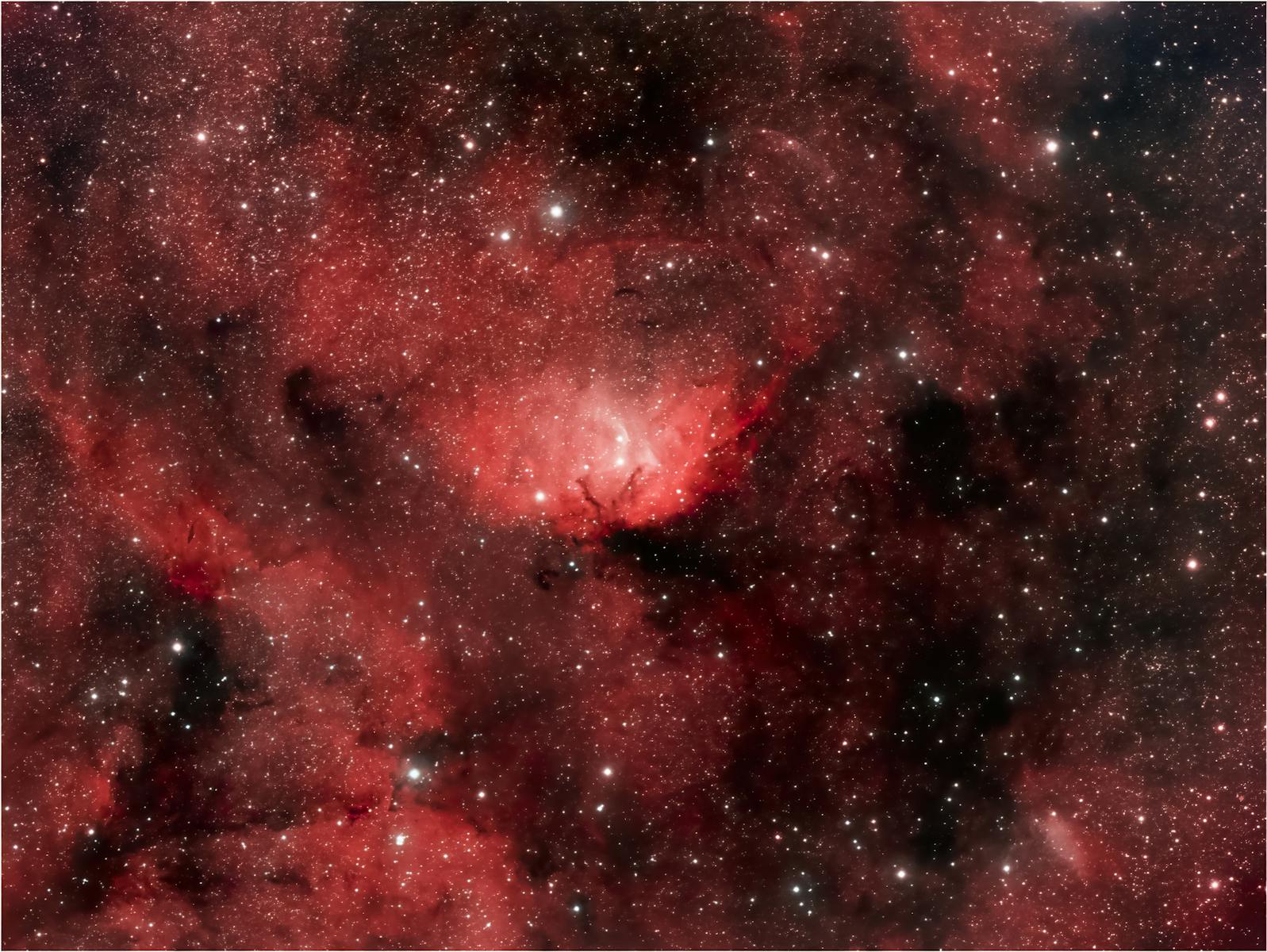 A breathtaking view of a red nebula surrounded by countless stars in the universe.